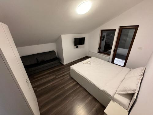 a small bedroom with a bed and a television at Cabana LUCDAR Valiug Crivaia in Văliug