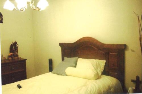 a bedroom with a bed with a wooden headboard at Casa de 3 pisos equipada in Tlaxcala de Xicohténcatl