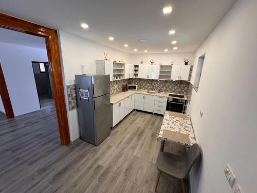 a kitchen with white cabinets and a stainless steel refrigerator at Cabana LUCDAR Valiug Crivaia in Văliug