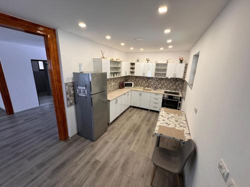 una cucina con armadi bianchi e frigorifero in acciaio inossidabile di Cabana LUCDAR Valiug Crivaia a Văliug