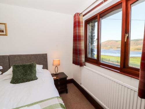 un dormitorio con una cama y una ventana en Green Hills Farm, en Greenodd