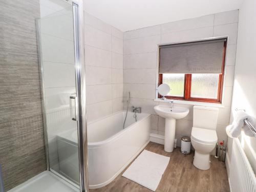 Un baño con bañera, inodoro y lavabo. en Green Hills Farm, en Greenodd