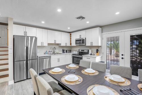 a kitchen with a table and chairs and a refrigerator at Family Reunion, Remodeled, King Beds, X-box, Desks in Las Vegas