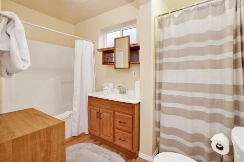 Un baño con lavabo, inodoro y ducha. en Mount Berkley Big Bear~ Walk to Village~ Games~, en Big Bear Lake