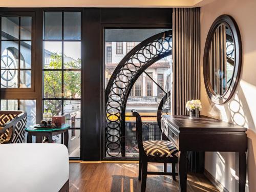 a room with a desk and a large window at Hue Serene Palace Hotel in Hue