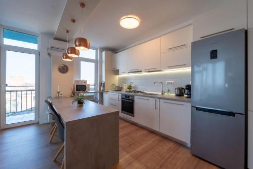 a large kitchen with white cabinets and a counter top at Modern Apollus Avenue - By OpenHouse apartments in Timişoara