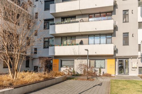an apartment building with a walkway in front of it at Modern Apollus Avenue - By OpenHouse apartments in Timişoara