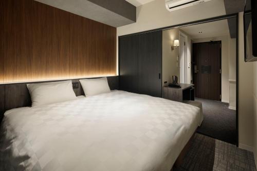 a large white bed in a hotel room at the b osaka-shinsekai in Osaka