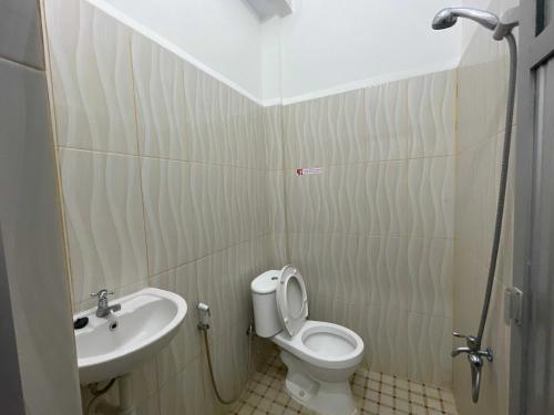 ein Bad mit einem WC und einem Waschbecken in der Unterkunft OYO 93297 Penginapan Musafir Syariah in Pangkajene