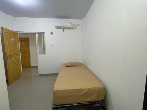 ein kleines Zimmer mit einem Bett in der Ecke in der Unterkunft OYO 93297 Penginapan Musafir Syariah in Pangkajene