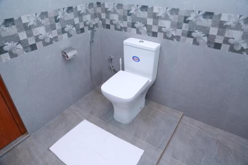 - une salle de bains avec des toilettes blanches dans une cabine dans l'établissement Rupa Villa, à Beruwala