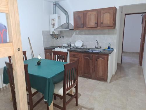 - une cuisine avec une table, des chaises et un évier dans l'établissement Hospedaje V del Valle, à San Fernando del Valle de Catamarca
