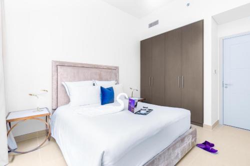 Dream Inn Apartments - Forte - The Opera District في دبي: غرفة نوم مع سرير أبيض كبير وخزانة