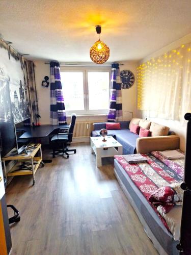 a living room with a couch and a desk at Cozy trendy spacious room in green area 12 min. near to the center Alexanderplatz in Berlin