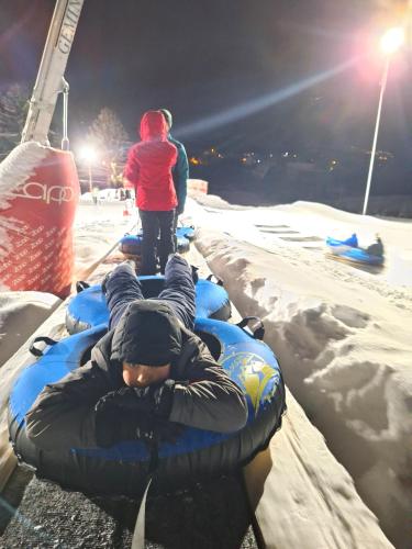 a person is laying on a raft in the snow at Pensiunea Sarah Bran in Bran