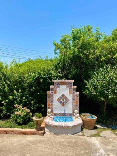 a stone monument in front of some bushes at PREERIA Pension in JEJU in Jeju
