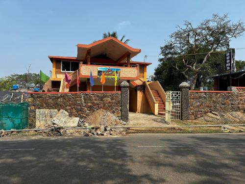 a house is being built with a stone wall at Leebon's Tamil kudill in Masinagudi