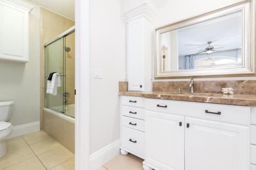 a white bathroom with a sink and a mirror at Luxurious Mountain Retreat-unparalleled Views in Alpine
