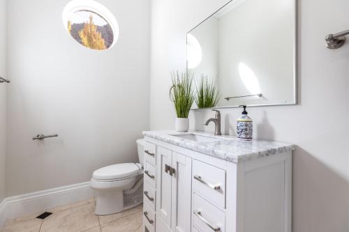 a white bathroom with a toilet and a sink at Luxurious Mountain Retreat-unparalleled Views in Alpine