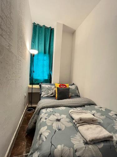1 dormitorio con 2 camas y una ventana azul en Tanih's Lodging, en Abu Dabi