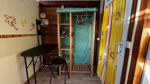 a room with a ladder and a table and chairs at Gîte La Rêverie - Guadeloupe in Saint-Claude