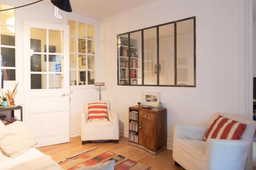 salon z kanapą, krzesłem i lustrem w obiekcie Charming 50 m love cocoon in Paris 10th w Paryżu