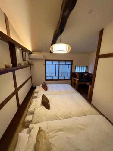 ein Schlafzimmer mit einem großen weißen Bett in einem Zimmer in der Unterkunft Imakumano Terrace - Dohachi An 道八庵 in Kyoto