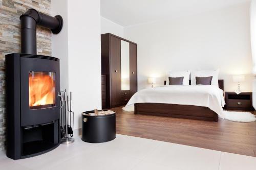 sala de estar con chimenea y cama en Rezydencja Sunny Hill, en Karpacz