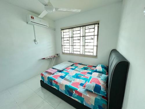 a bedroom with a bed in a room with a window at Chempaka Homestay (Near to UTP UiTM Seri Iskandar) in Seri Iskandar