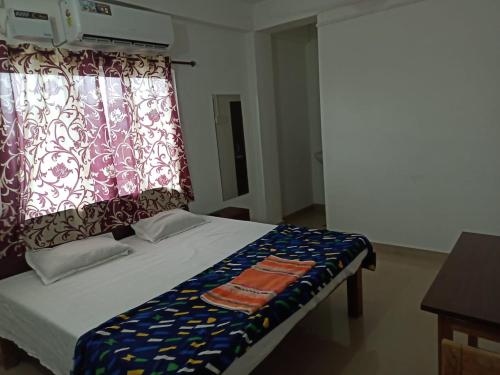 a bedroom with a bed with a curtain and a window at Punjab Residency in Port Blair