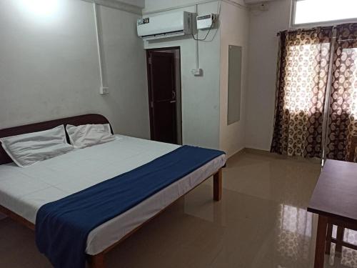 1 dormitorio con cama, mesa y ventana en Punjab Residency, en Port Blair