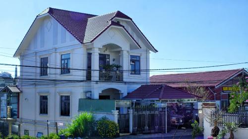 a white house with a metal roof at HUNA House in Da Lat