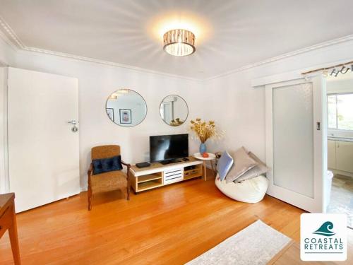 a living room with a television and a chair at Shudderbug Shack in Inverloch