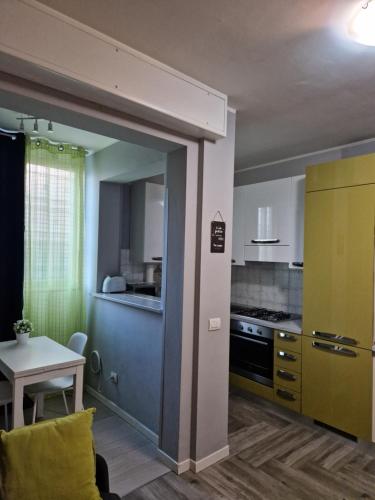 una cocina con una puerta azul que conduce a una cocina con mesa en Appartamento Piccola Perla, en Cologno Monzese