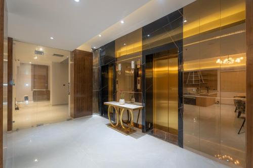 a bathroom with a table in a room with glass walls at De Crown Inn in Jogīkuti