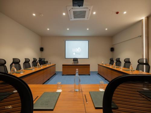 a conference room with a screen in the middle of it at Luxo Kochi in Ernakulam