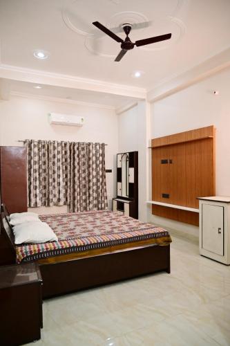 a bedroom with a bed and a ceiling fan at Surendra Villa Home Stay in Ayodhya
