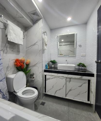 y baño con aseo y lavamanos. en Condo Azur Suites B207 near Airport, Netflix, Stylish, Cozy with swimming pool en Lapu Lapu City