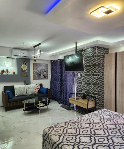 Habitación con cama, sofá y TV. en Condo Azur Suites B207 near Airport, Netflix, Stylish, Cozy with swimming pool en Lapu Lapu City