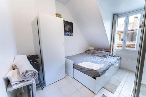 a small room with a small bed and a window at Lumineux. Studio République/Bastille, Marais in Paris