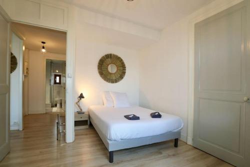 - une chambre avec un lit blanc et un miroir dans l'établissement « Grand Verger » - parking gratuit, à Chambéry