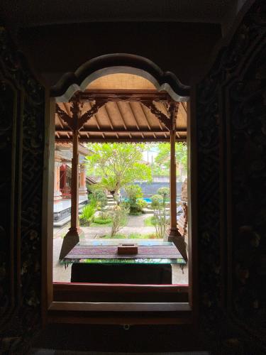 an open window with a view of a garden at Aura Bisma Guesthouse in Ubud