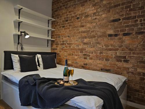 a bed with a table with two glasses of wine at URABN APARTMENTS Studio with garden No 2A Chorzów Katowice FREE PRIVATE PARKING in Chorzów