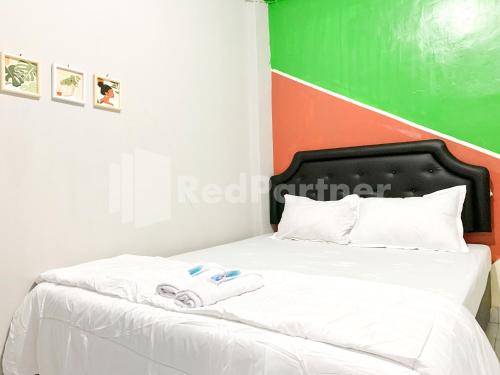 a bedroom with a bed with two towels on it at RedDoorz Syariah @ D'KostMarto UTY in Yogyakarta