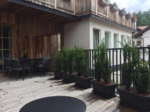a patio with potted plants on a wooden deck at Appartements Innerkofler Mountain Home in San Candido