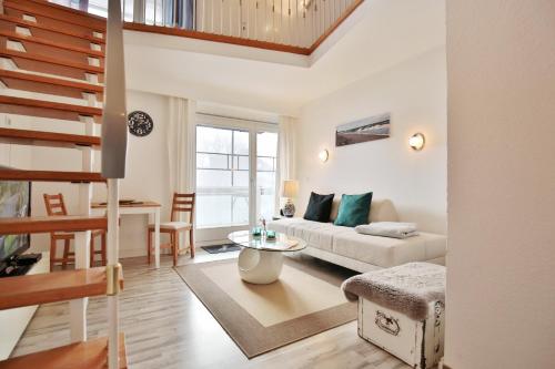 a living room with a couch and a table at Haus Miramar Treffert Appartement 21 in Niendorf