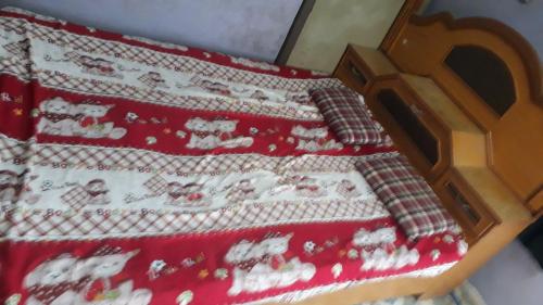 - un lit avec un couvre-lit rouge et des chats dans l'établissement Vinayak Niwas, à Miraj