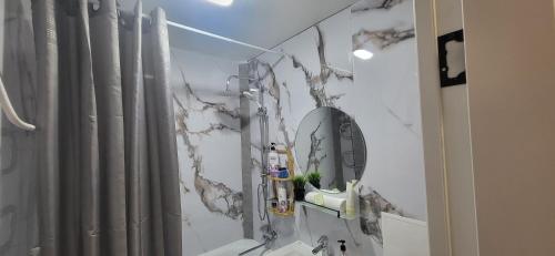 y baño con ducha y espejo. en Lux Home Astana, en Öskemen