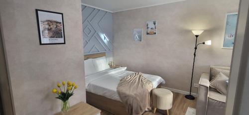 Lux Home Astana في أوست - كامينوغورسك: غرفة نوم بسرير ومصباح وزهور