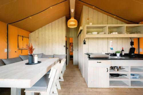 eine Küche und ein Esszimmer mit einem Tisch und Stühlen in der Unterkunft Glampingzelt Family - Lodge in Soltau